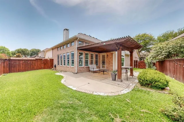 a view of a house with backyard and sitting area