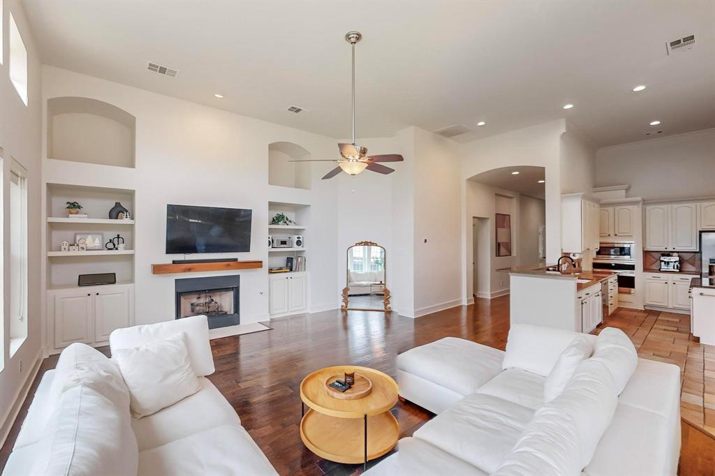 9964 Madrone Drive Frisco, TX 75033 - Photo 4 of 39 a living room with furniture a flat screen tv and kitchen view