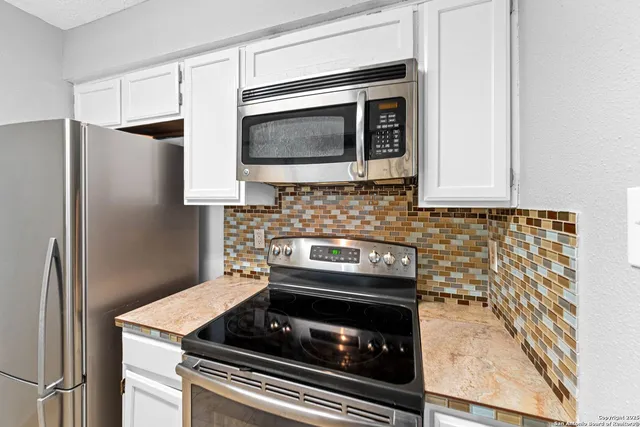 a kitchen with granite countertop cabinets and steel stainless steel appliances