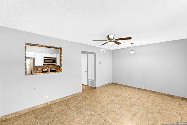a view of a big room with wooden floor and windows