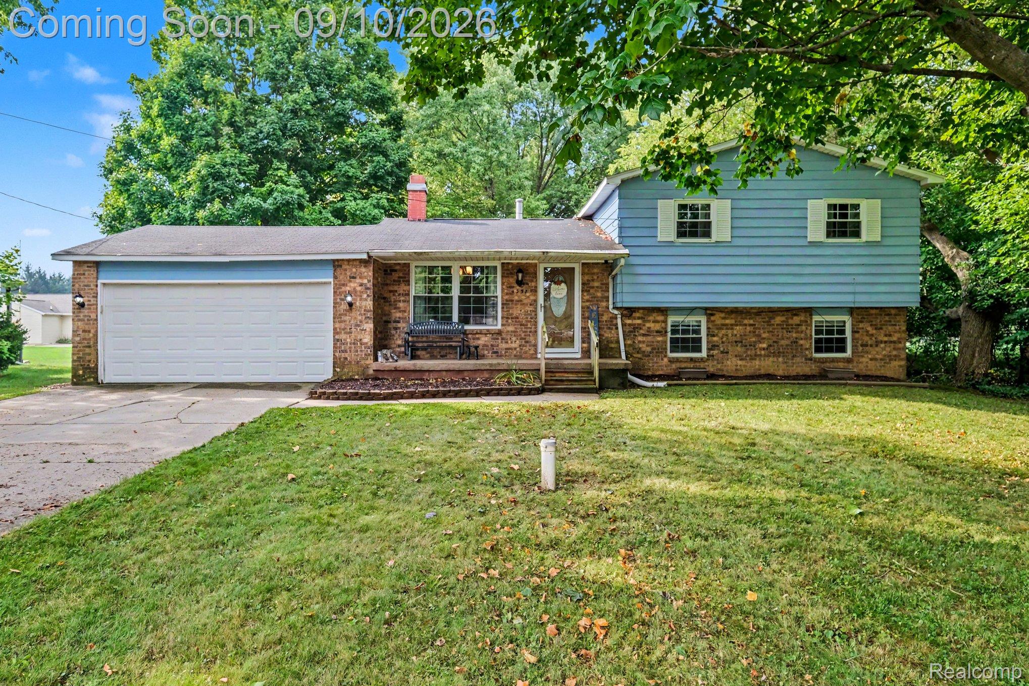 4338 Crosby Road Flint, MI 48506 - Photo 1 of 16 Brick and siding exterior with an attached garage, mature front yard, and a front entry porch