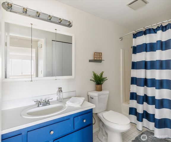 a bathroom with a sink a toilet a shower and a mirror