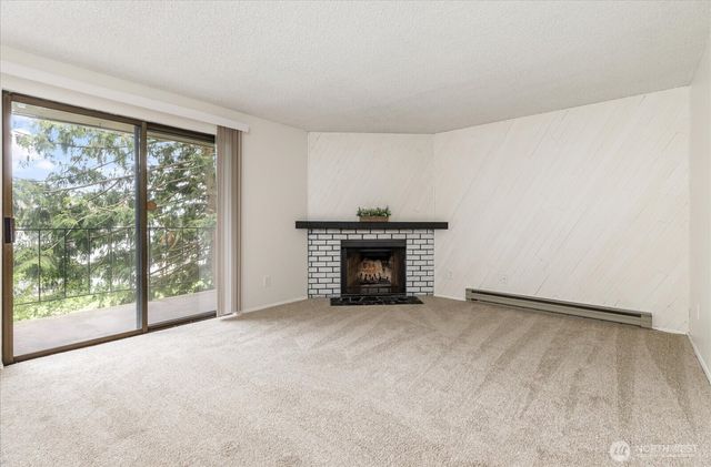 a view of an empty room with a fireplace and a window