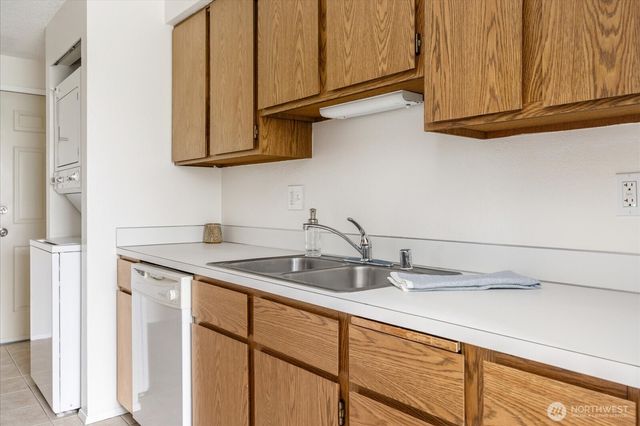 a kitchen with stainless steel appliances granite countertop white cabinets a sink and dishwasher