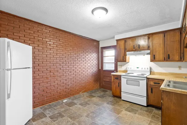 a kitchen with stainless steel appliances granite countertop a stove a sink and a refrigerator