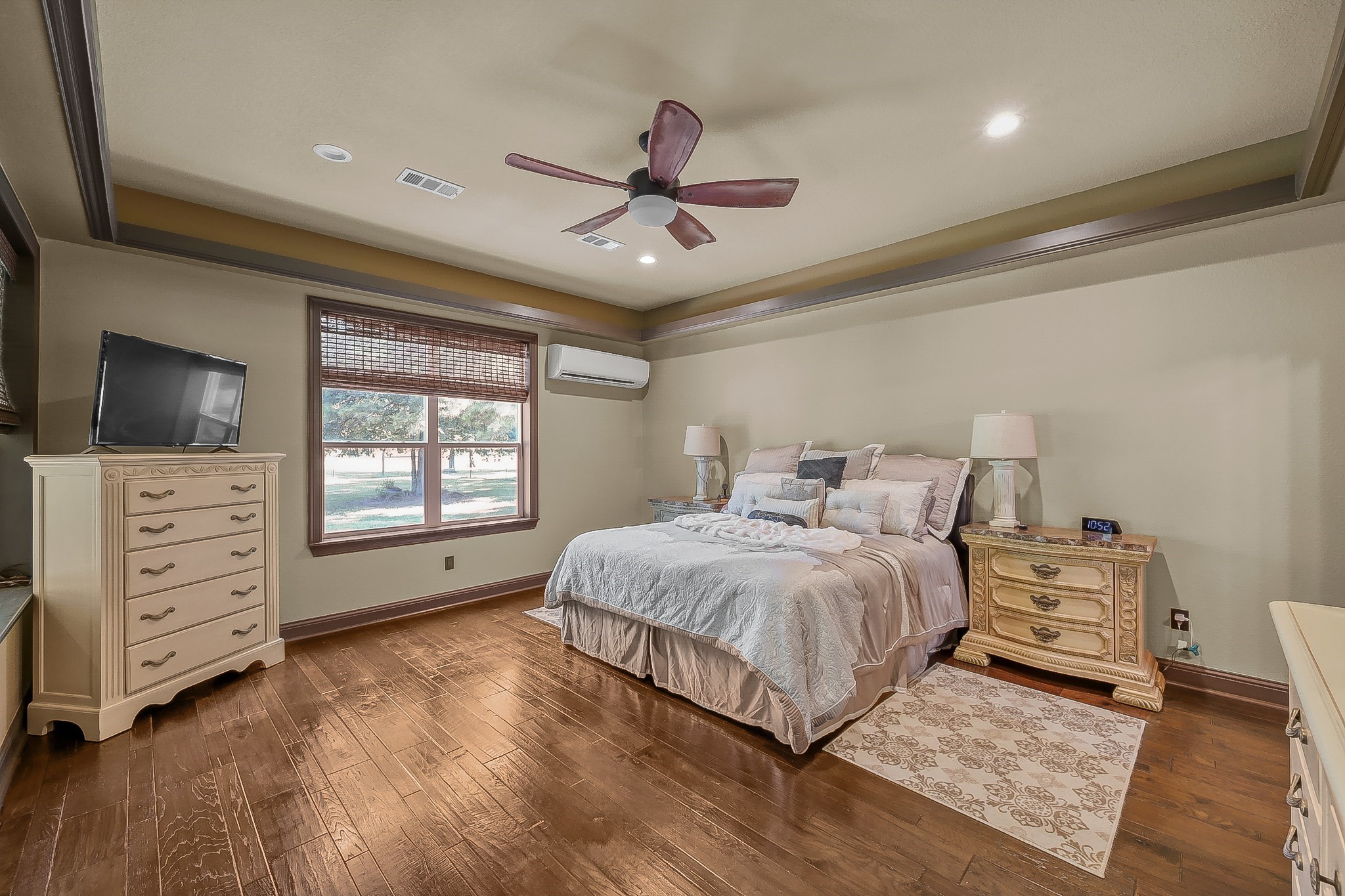 1183 Jones Road New Waverly, TX 77358 - Photo 21 of 40 a spacious bedroom with a bed and a flat tv screen on dresser