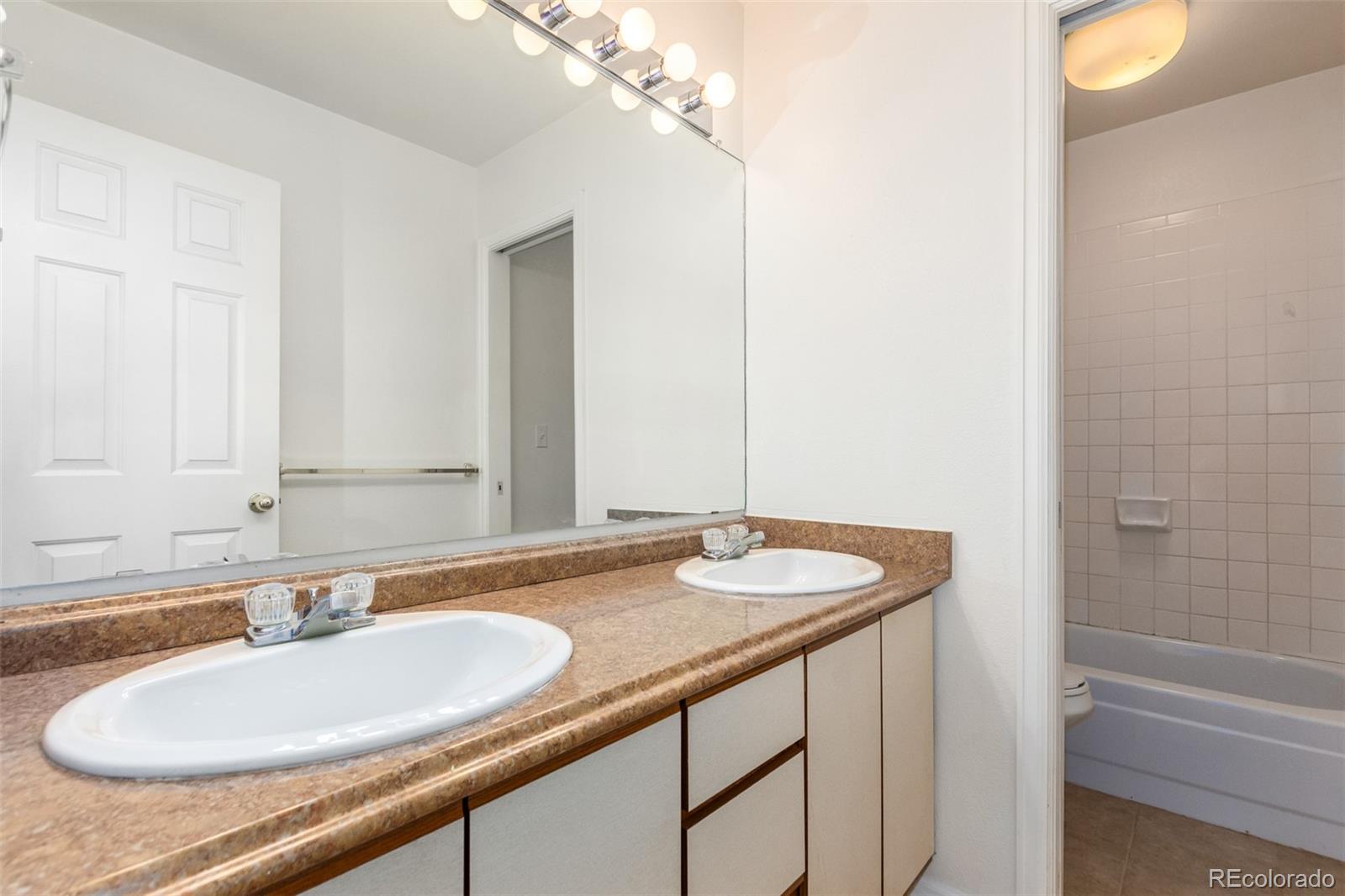 515 Cook Street Denver, CO 80206 - Photo 28 of 40 a bathroom with a granite countertop sink and a mirror