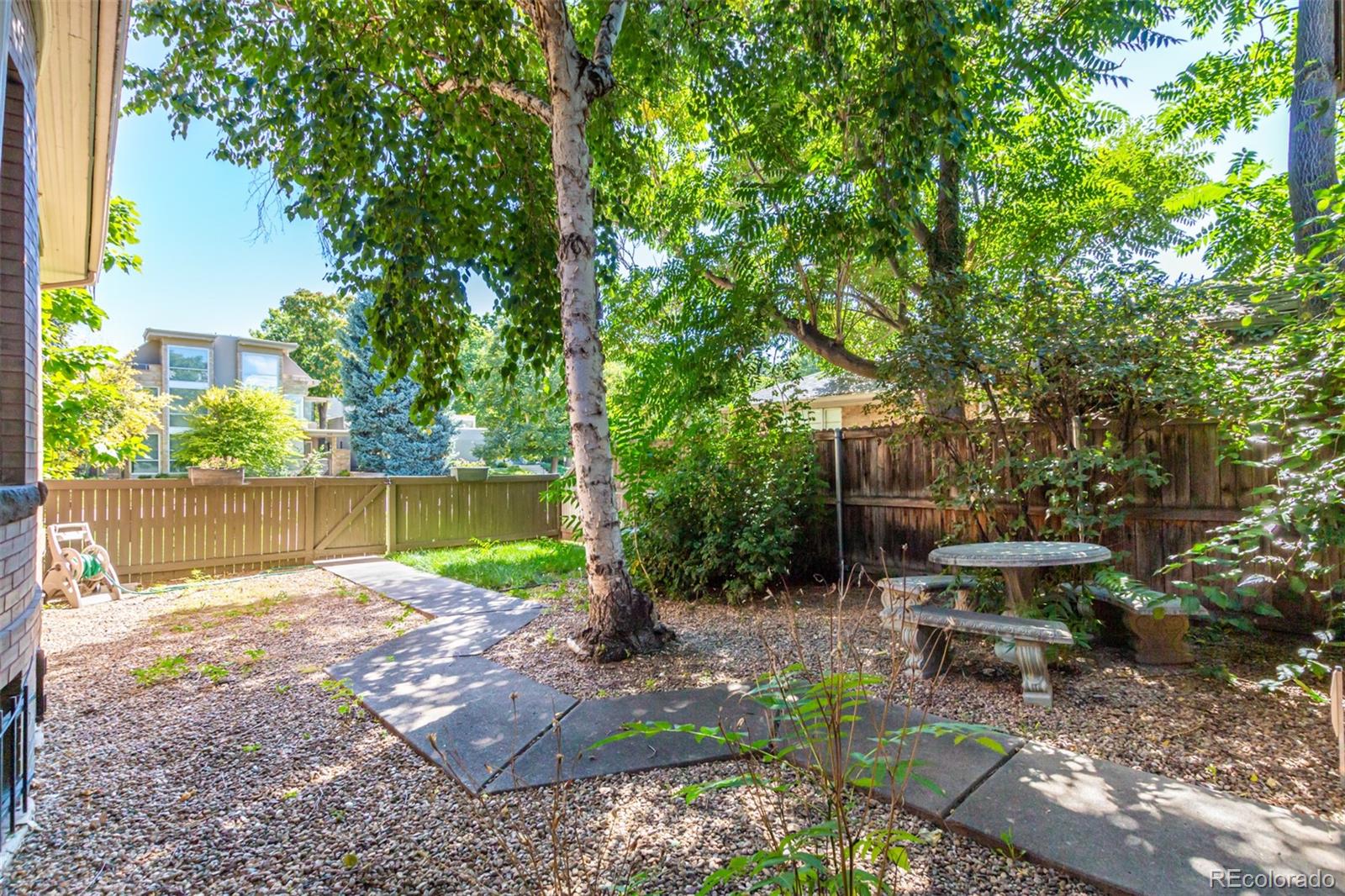 515 Cook Street Denver, CO 80206 - Photo 9 of 40 a view of a garden with a bench and a large tree