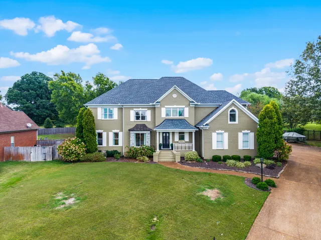 a front view of a house with a garden and plants