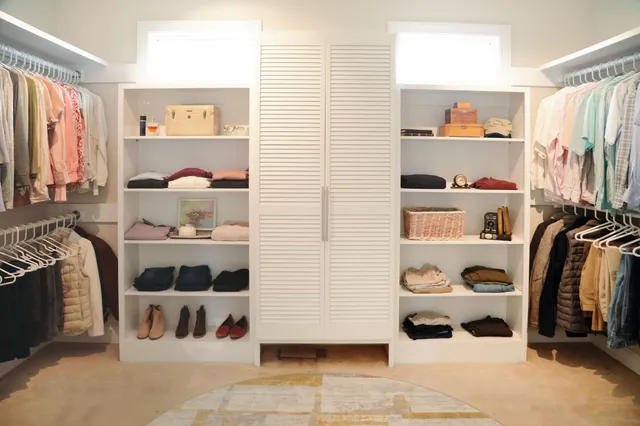 a view of walk in closet with clothes and shoes