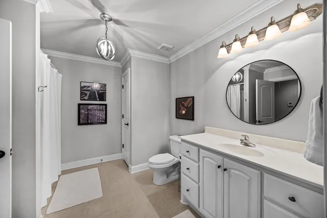 a spacious bathroom with a toilet a sink and a mirror