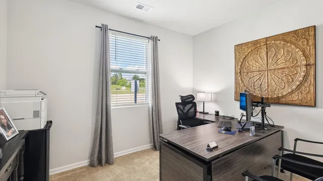 a view of a workspace with furniture and a window