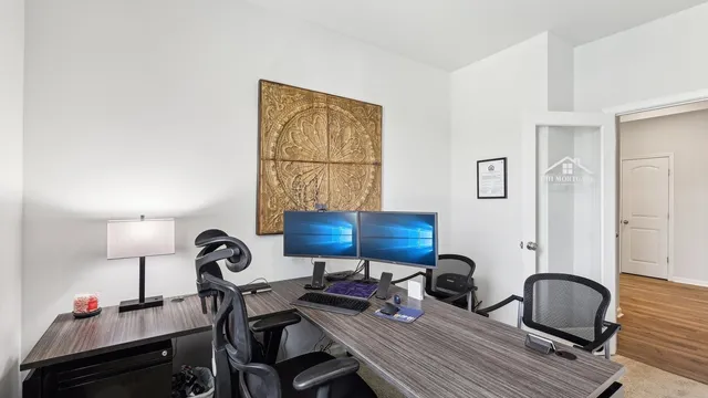 a view of a workspace with furniture and a window
