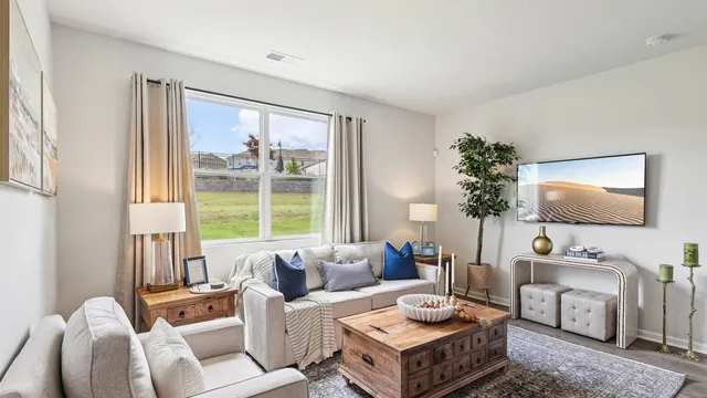 a living room with furniture a flat screen tv and a large window