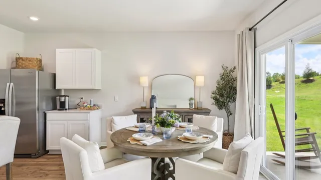 a view of a dining room with furniture a rug and wooden floor