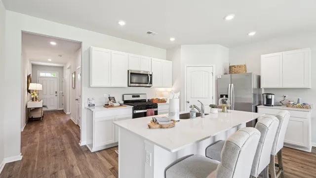 a kitchen with white cabinets and stainless steel appliances