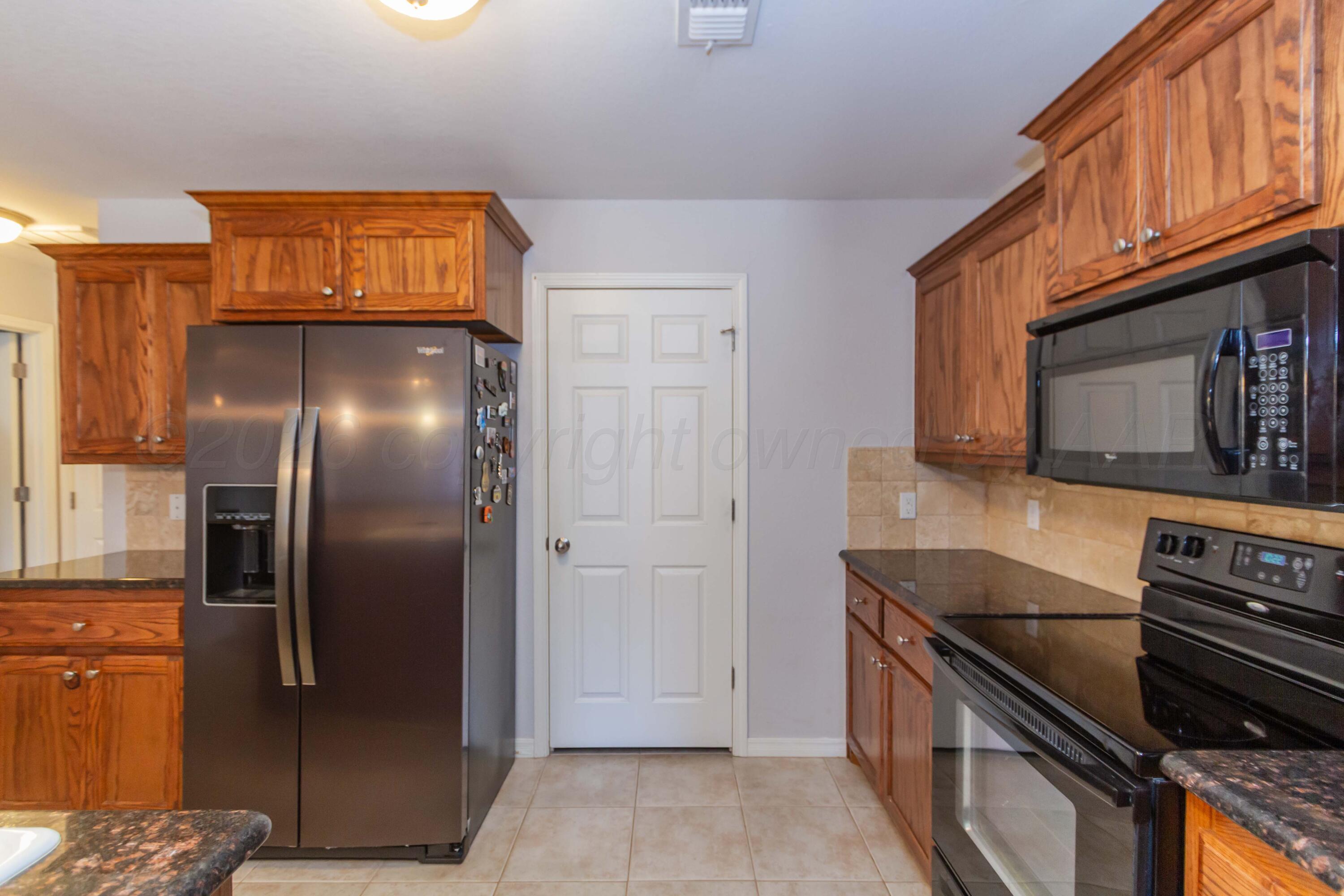2802 Steve's Way Amarillo, TX 79118 - Photo 11 of 30 a kitchen with stainless steel appliances granite countertop a refrigerator and a stove top oven