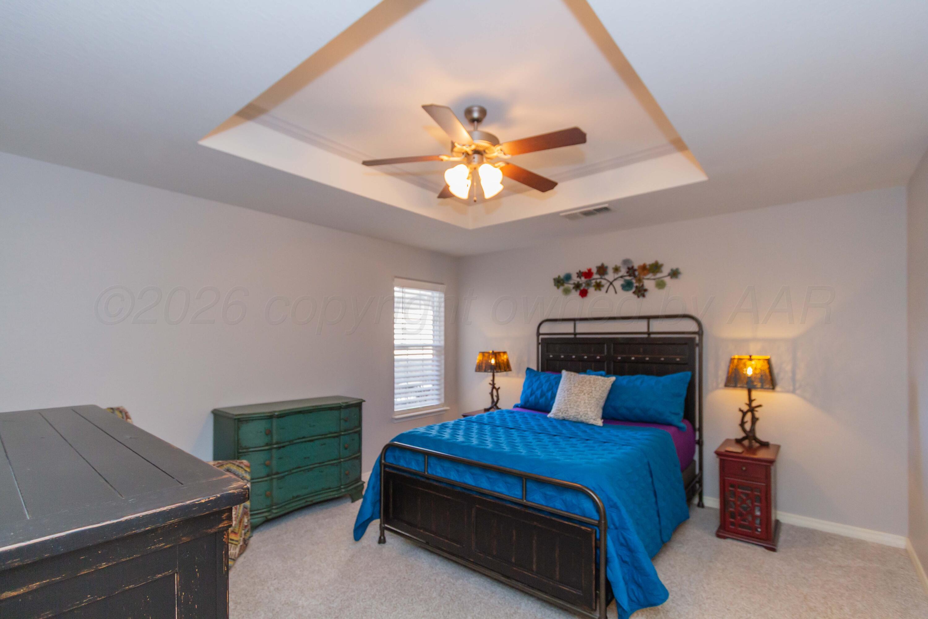 2802 Steve's Way Amarillo, TX 79118 - Photo 15 of 30 a bedroom with a bed and a chandelier