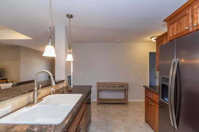 a kitchen with stainless steel appliances granite countertop a sink a stove and a refrigerator