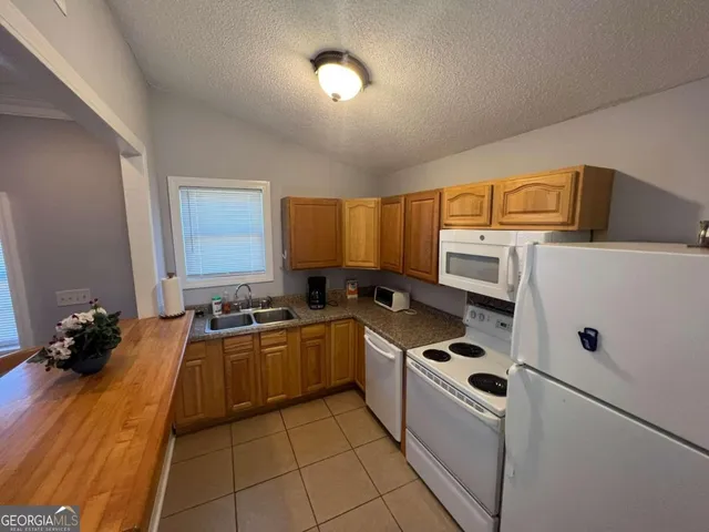 a kitchen with stainless steel appliances a stove a sink and a refrigerator