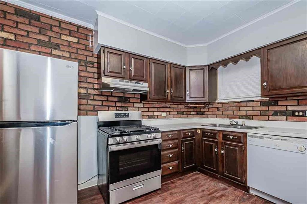 97 Royal Street Pittsburgh, PA 15212 - Photo 11 of 24 a kitchen with stainless steel appliances a stove a sink and a refrigerator