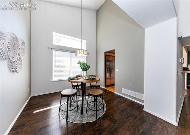 995 Winebrook Way Fountain, CO 80817 - Photo 7 of 44 Dining room with high vaulted ceiling and dark wood-type flooring