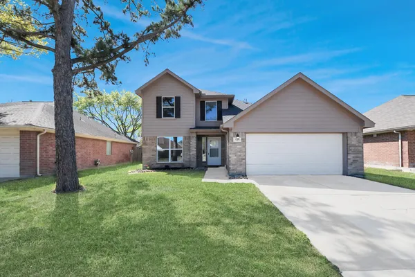a front view of a house with a yard and garage