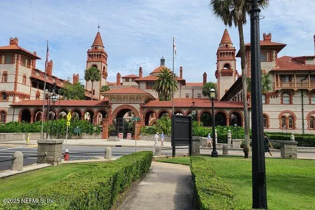 a front view of a building with a garden and plants