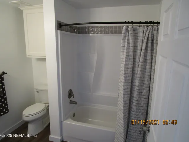 a bathroom with a shower curtain and toilet
