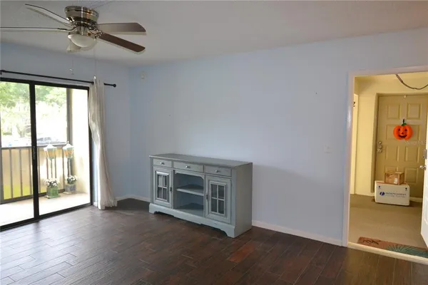 an empty room with windows and fan