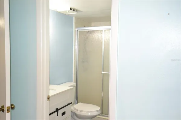 a bathroom with a granite countertop bathtub shower sink mirror and toilet