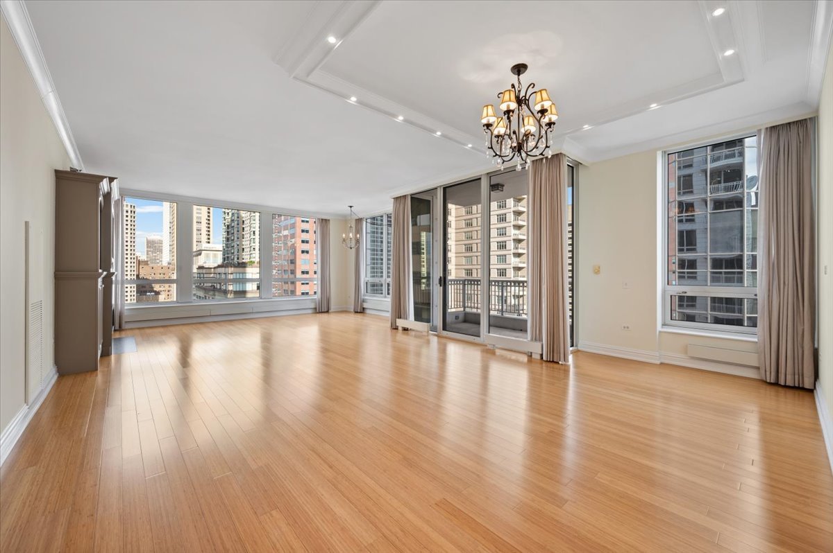 55 East Erie Street, Unit 1903 Chicago, IL 60611 - Photo 5 of 39 a view of an empty room with window and wooden floor