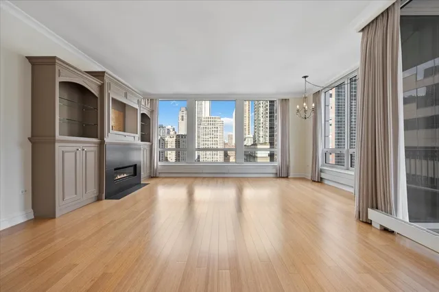 a view of a livingroom with wooden floor and a fireplace