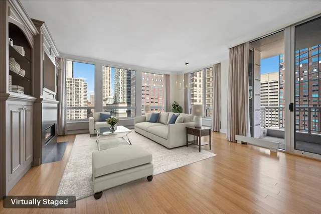 a living room with furniture floor to ceiling window and wooden floor
