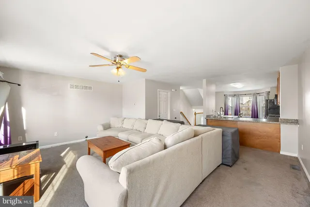 a living room with furniture and a ceiling fan