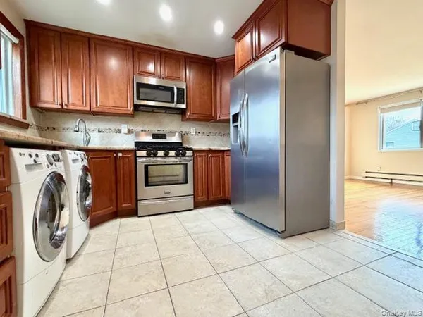 a kitchen with granite countertop a refrigerator and a stove top oven