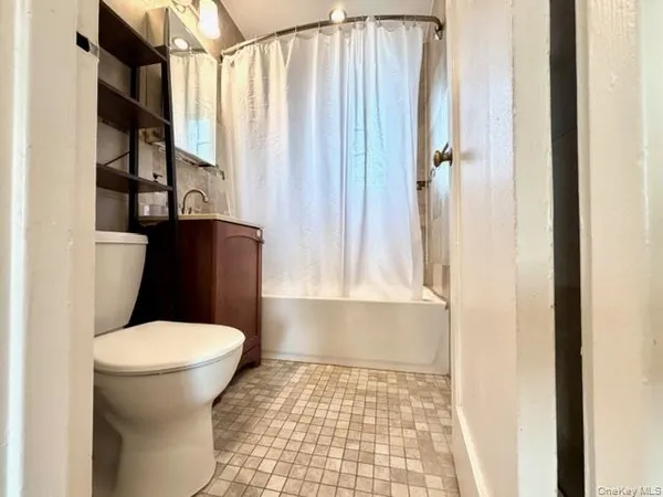 a bathroom with a toilet and a shower curtain