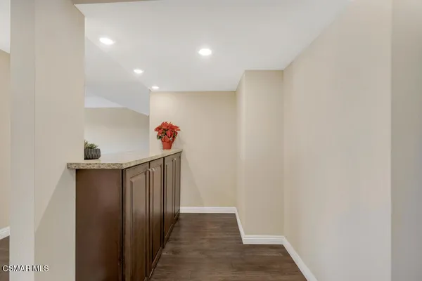 a view of an empty room with wooden floor and a fireplace