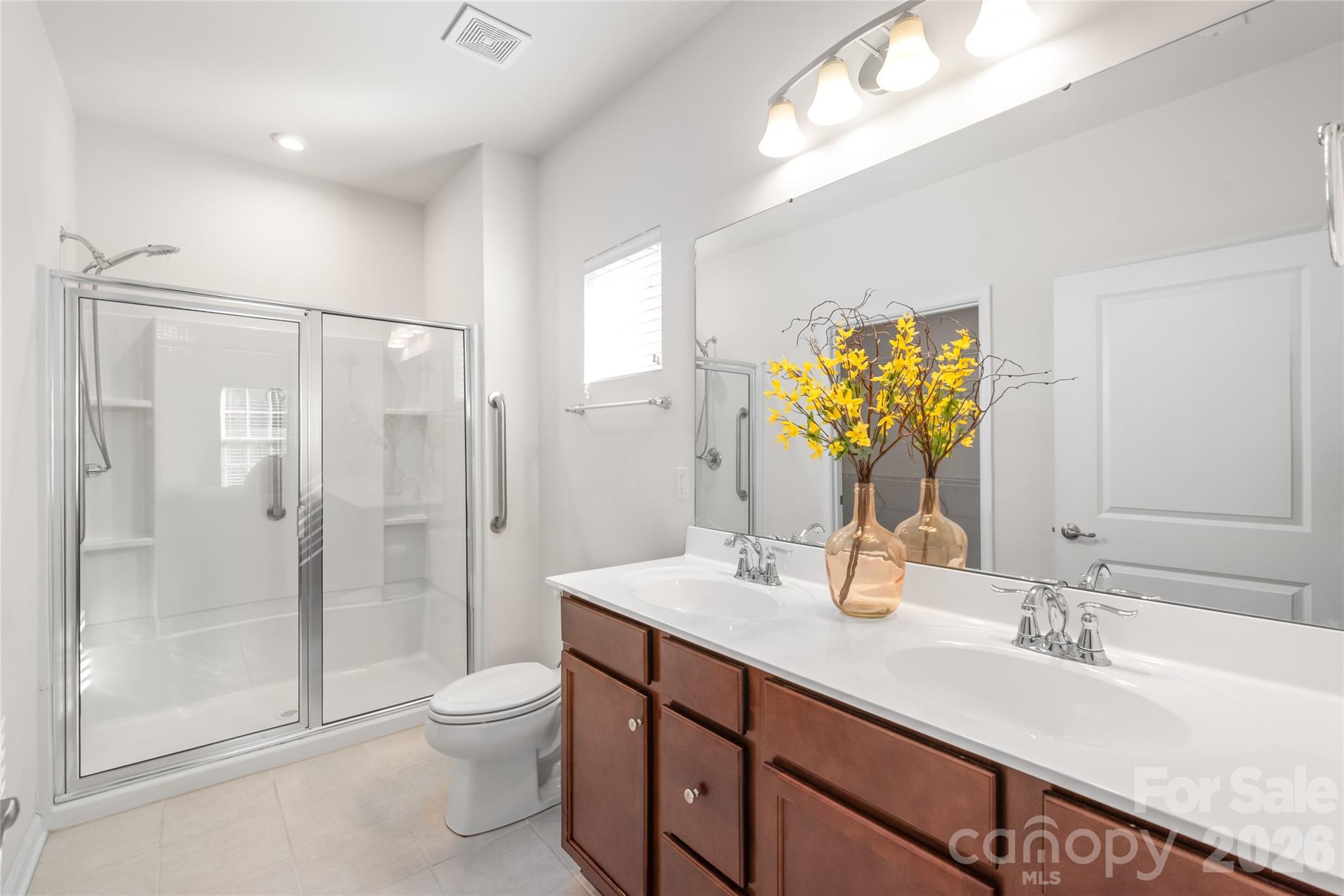 1960 Slippery Rock Lane Monroe, NC 28112 - Photo 16 of 32 a bathroom with a granite countertop sink toilet a large mirror a shower and vanity