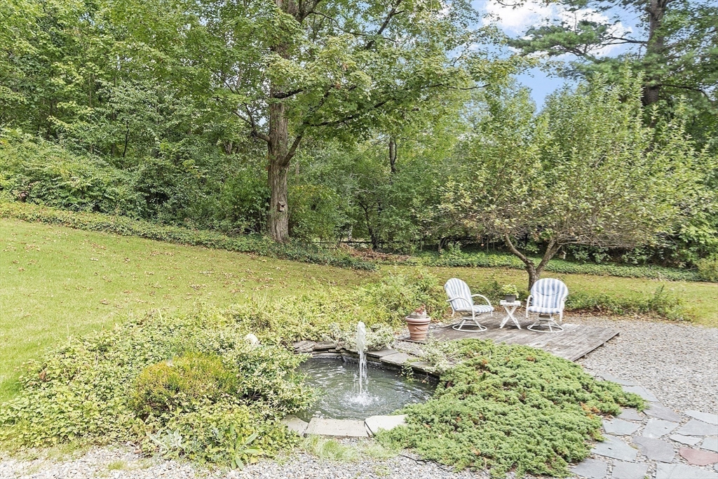 54 Kemp Street Groton, MA 01450 - Photo 4 of 38 a view of a lake with a bench and trees