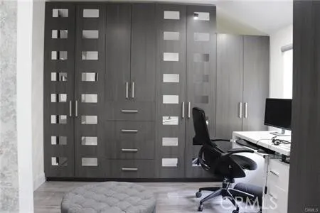 a view of a workspace with furniture and a window