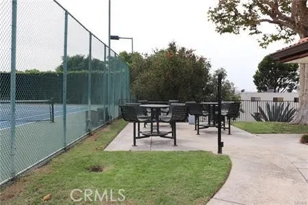 a backyard of a house with table and chairs potted plants