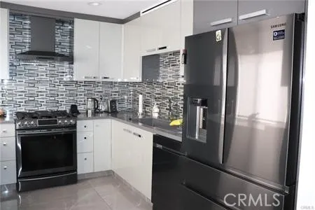 a kitchen with stainless steel appliances granite countertop a refrigerator and a stove