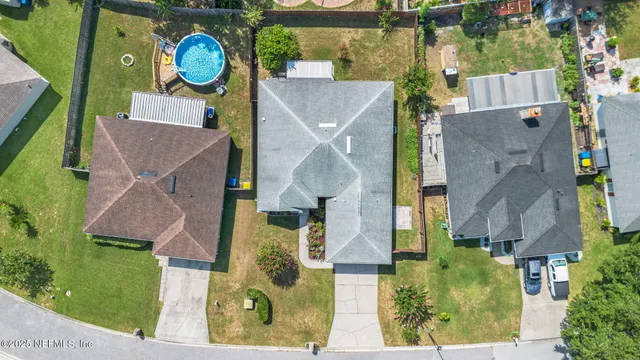 an aerial view of residential houses with outdoor space and parking
