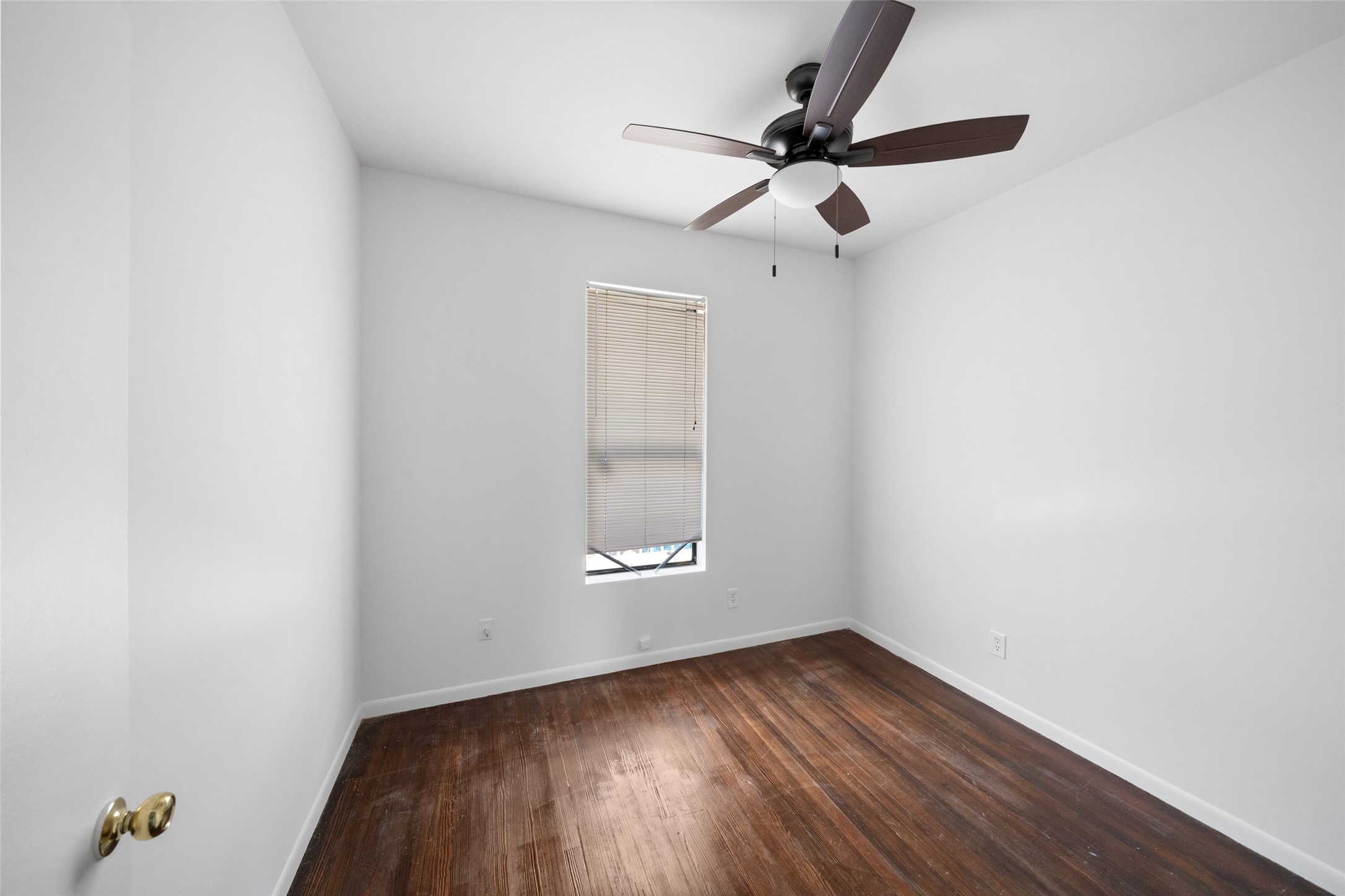 518 Hawthorne Street, Unit 2 Houston, TX 77006 - Photo 11 of 15 an empty room with wooden floor fan and windows