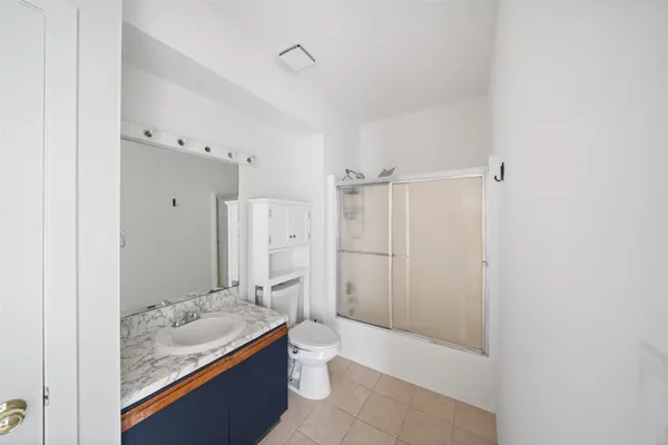 a bathroom with a granite countertop sink a toilet and shower
