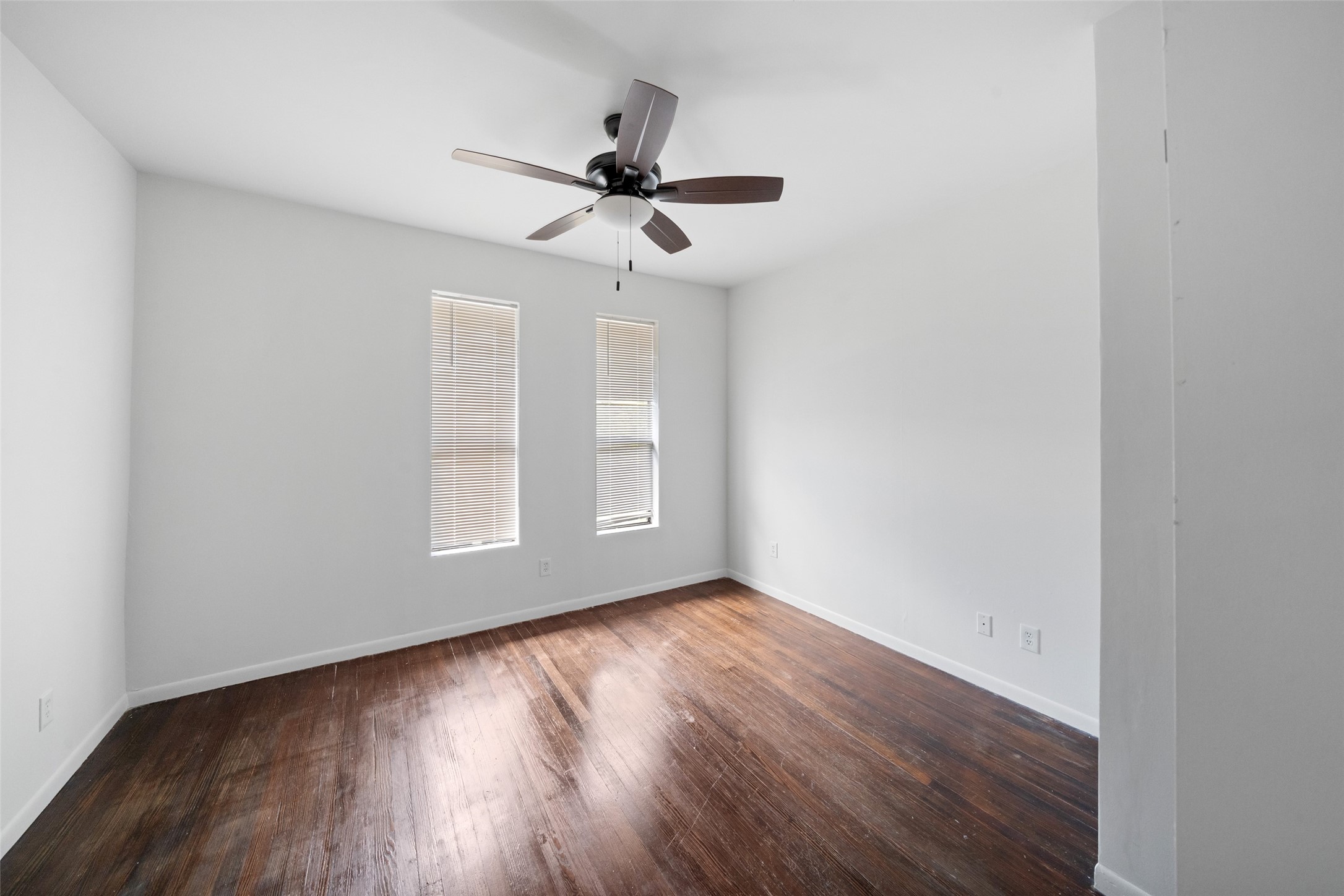 518 Hawthorne Street, Unit 2 Houston, TX 77006 - Photo 13 of 15 an empty room with wooden floor fan and windows