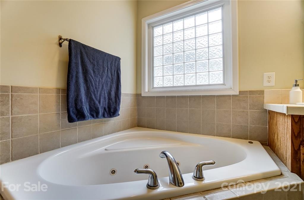 9180 Meadowood Road Mount Pleasant, NC 28124 - Photo 27 of 37 a bath tub sitting in a bathroom next to a window