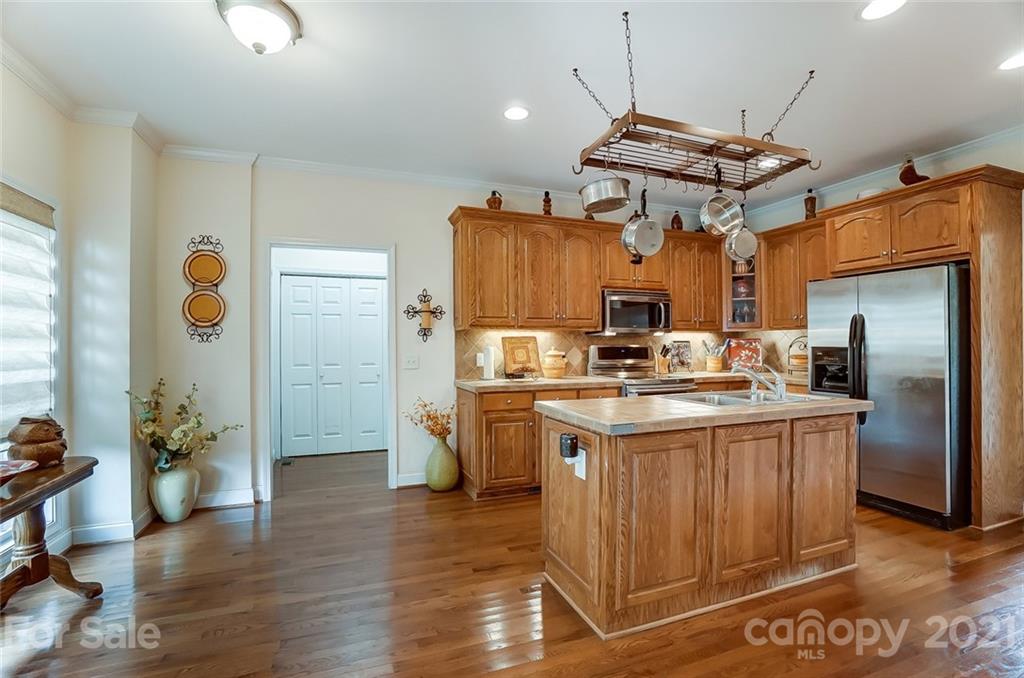 9180 Meadowood Road Mount Pleasant, NC 28124 - Photo 10 of 37 a kitchen with stainless steel appliances granite countertop a refrigerator a sink dishwasher and a dining table with wooden floor