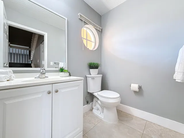 a bathroom with a toilet sink vanity and mirror